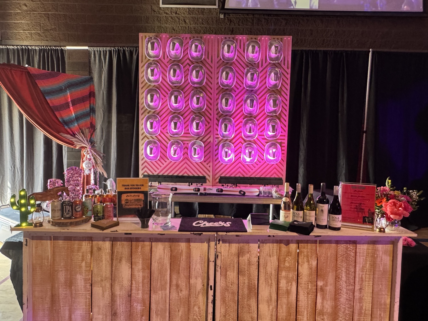 Themed mobile bar catering with pink lighting bottle wall and Sips signature cocktail menu